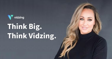 Vidzing female founder wears a black sweater and smiles for the camera
